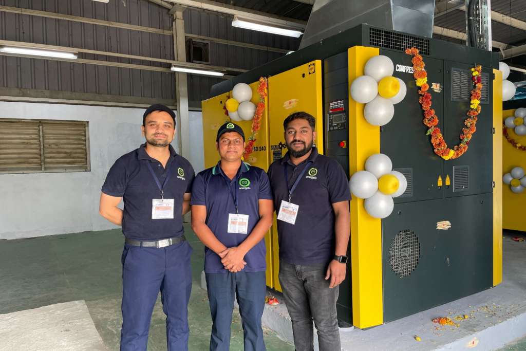 Industrial compressor installation and commissioning team at a manufacturing plant showcasing energy-efficient compressed air system infrastructure.